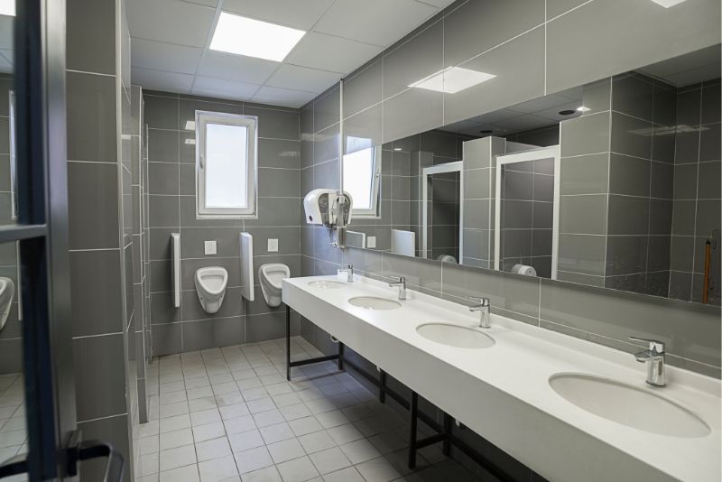 A commercial bathroom with wall tiles